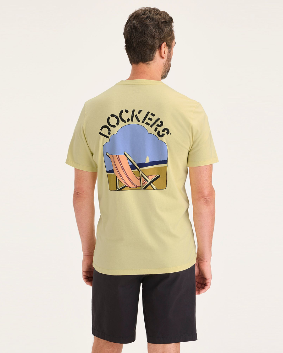 Back view of model wearing 90s Beach Dusty Yellow Men's Slim Fit Logo Tee.