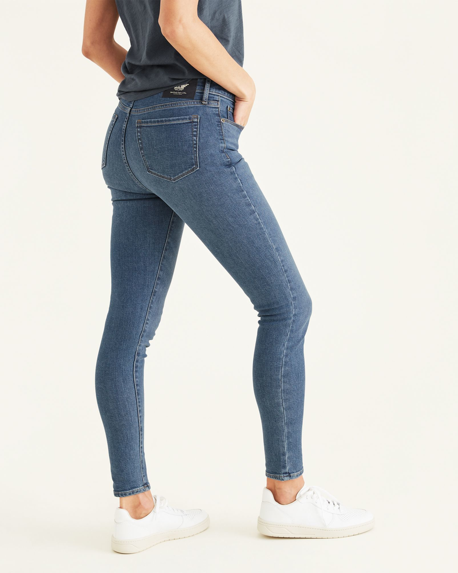 Side view of model wearing Cassidy Light Rinse Women's Mid-Rise Skinny Jean Cut Pants.