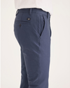 Side view of model wearing Crown Blue Men's Skinny Fit Smart 360 Knit Chino Pants.