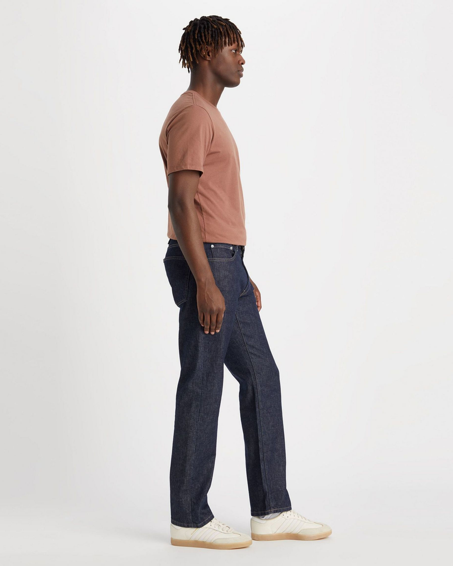 Side view of model wearing Dark Indigo Rinse Men's Slim Fit Smart 360 Flex Jean Cut Pants.