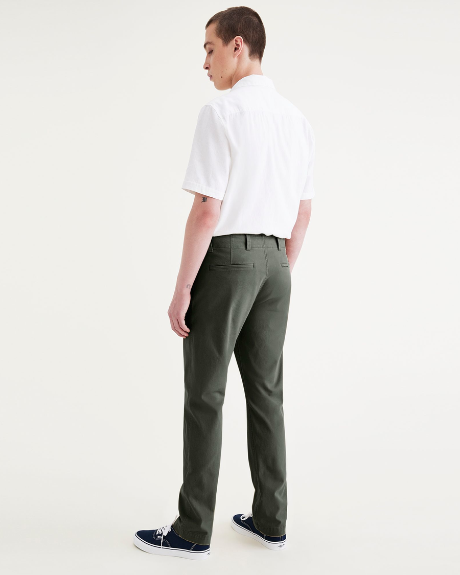 Back view of model wearing Deep Forest Alpha Chino Pants, Slim Fit.