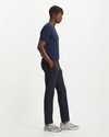 Side view of model wearing Dockers Navy Men's Slim Tapered Fit Smart 360 Flex Alpha Chino Pants.