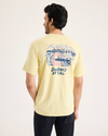 Back view of model wearing Dusty Yellow Men's Slim Fit Logo Tee.