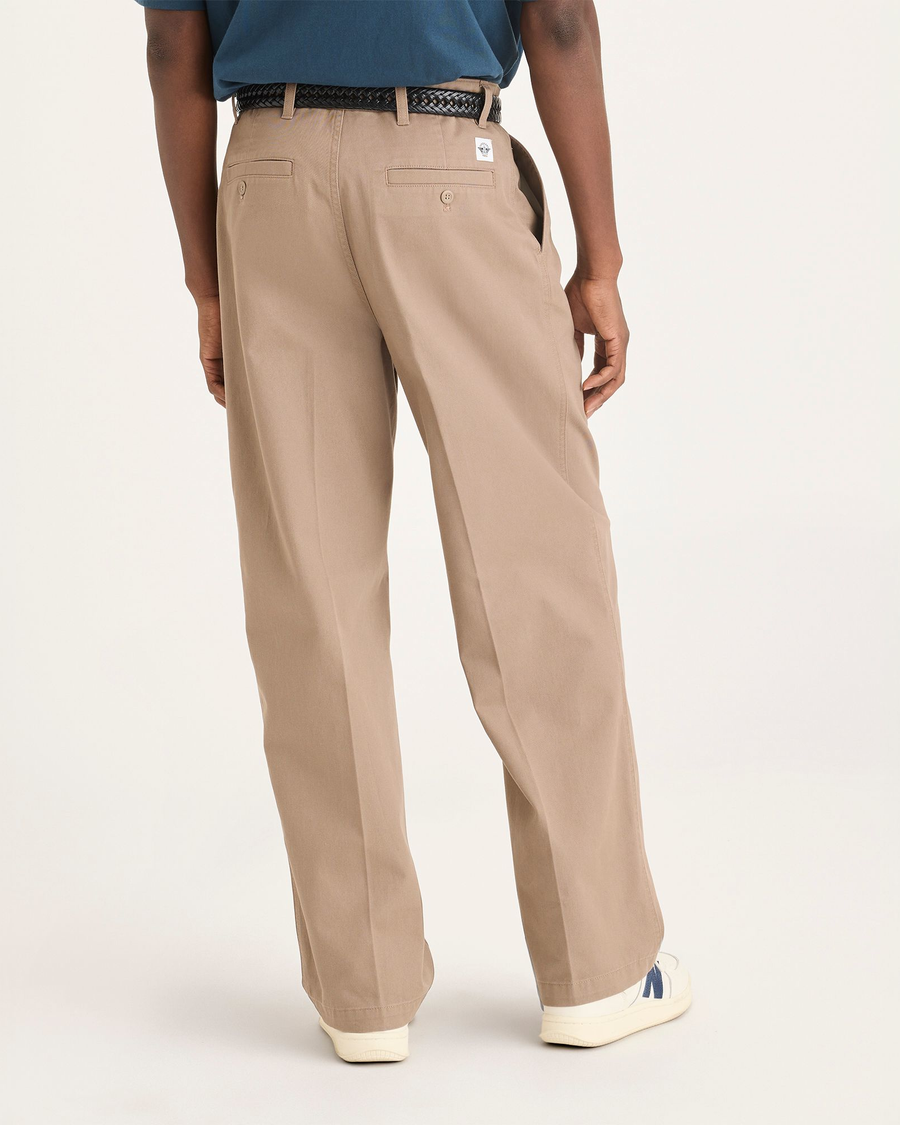 Back view of model wearing Fossil Men's Loose Fit Eighty-Six Original Pleated Chino Pants.