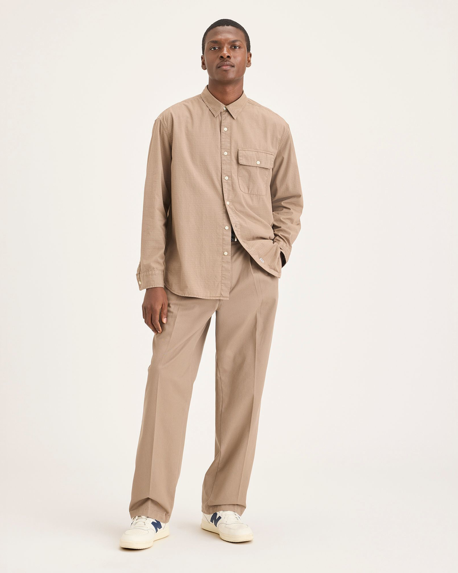 Front view of model wearing Fossil Men's Loose Fit Eighty-Six Original Pleated Chino Pants.