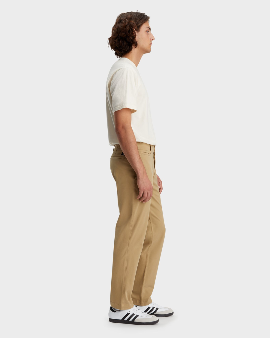 Side view of model wearing Harvest Gold Alpha Chino Pants, Straight Fit.