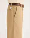 Side view of model wearing Harvest Gold Eighty-Six Alpha Chino Pants, Loose Fit.