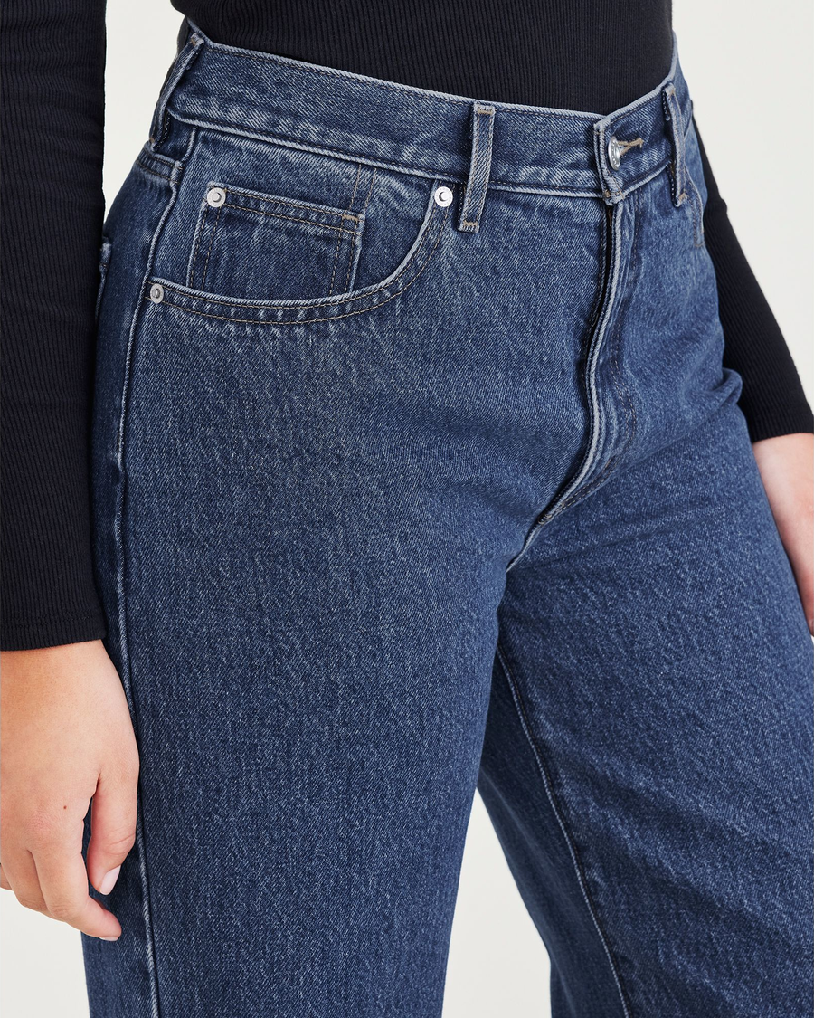 View of model wearing Medium Indigo Stonewash Women's Relaxed Fit Mid-Rise Jeans.