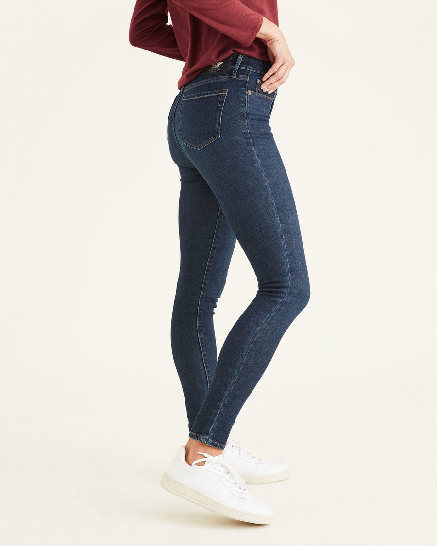 Side view of model wearing Moonlight Dark Rinse Women's Mid-Rise Skinny Jean Cut Pants.